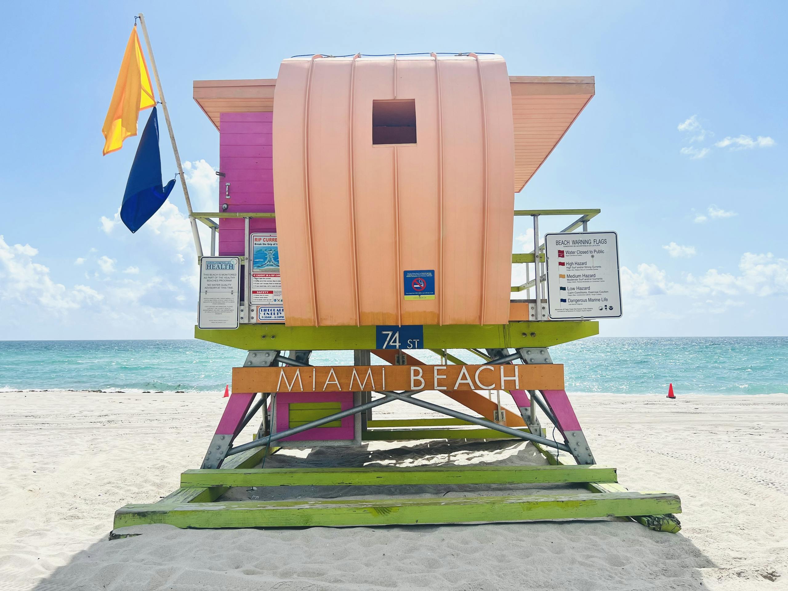 Colorful lifeguard tower on a sunny day at Miami Beach with turquoise water in the background.